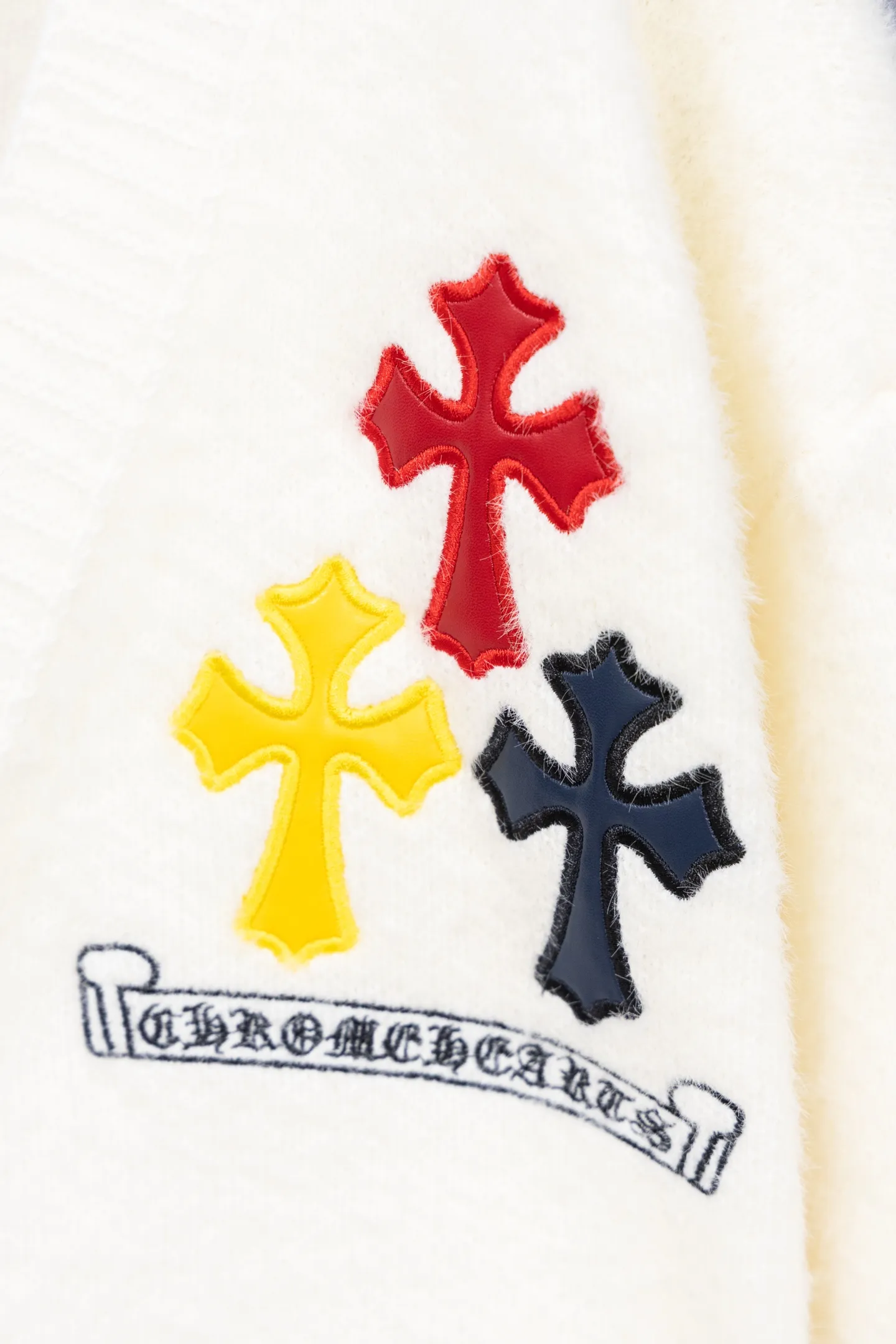 P300 Chrome Hearts CH Chrome Hearts 2026 new cross loose knitted V-neck cardigan Fabric: Made of plush textured knitted material, soft to the touch and with a lazy atmosphere; Decoration: Red, yellow, and black cross ornaments on the chest, paired with brand logo patches, which are iconic elements of street fashion brands (such as Chrome Hearts style), enhancing visual recognition; Version: Loose version + single-row metal button design, combining casual feeling and practicality. 2. Style and Adaptation Style: It combines dark street style and gentle knitted texture, which belongs to the tone of "sweet and cool mix"; Scenario: Can be worn with a T-shirt/suspender to create a daily street look, or can be layered with a shirt for light casual wear. Color: Black White Size: M L XL
